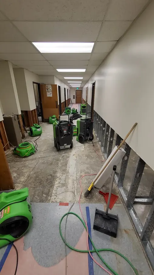 Air movers and a dehumidifier drying a flood-cut South LA hallway after water extraction